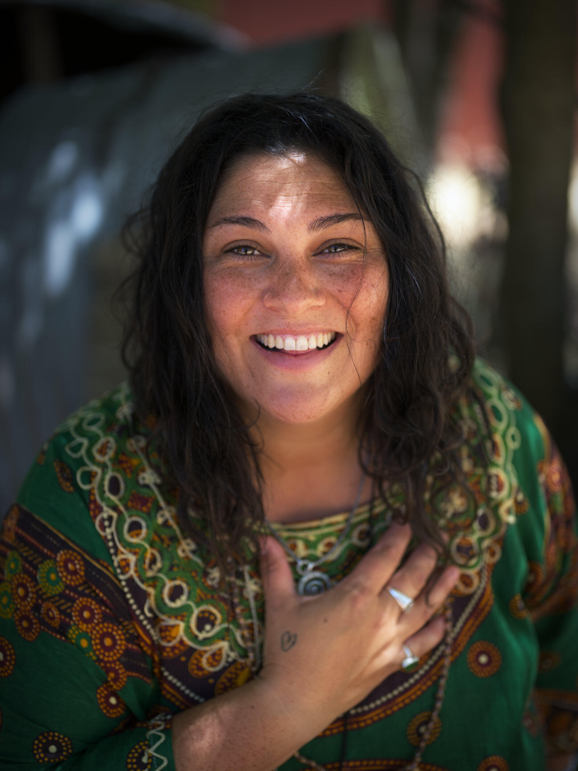 A colourful portrait of a smiling spirited woman with her hand on her heart in Mount Eliza, Victoria