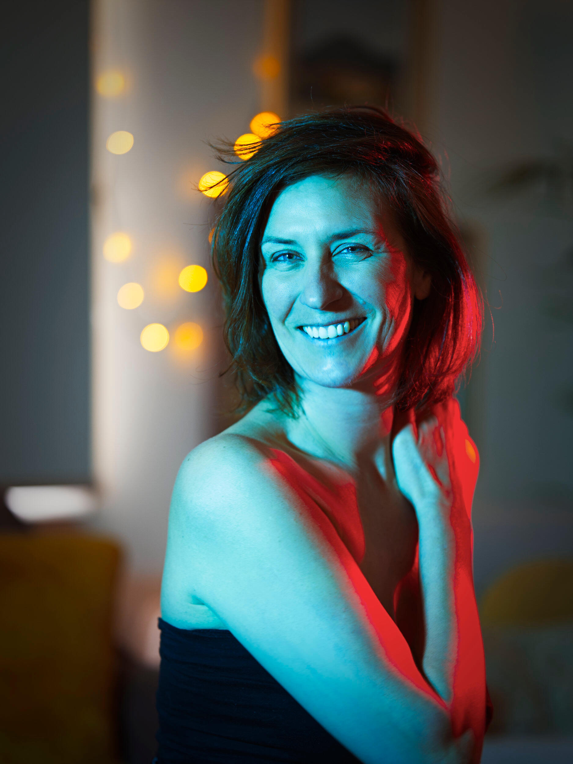 A corporate professional at a cafe I shot this portrait while we sipped coffee at a cafe in Frankston, Victoria. I loved the red and blue lighting contrasting skin tones against the background fairy lights