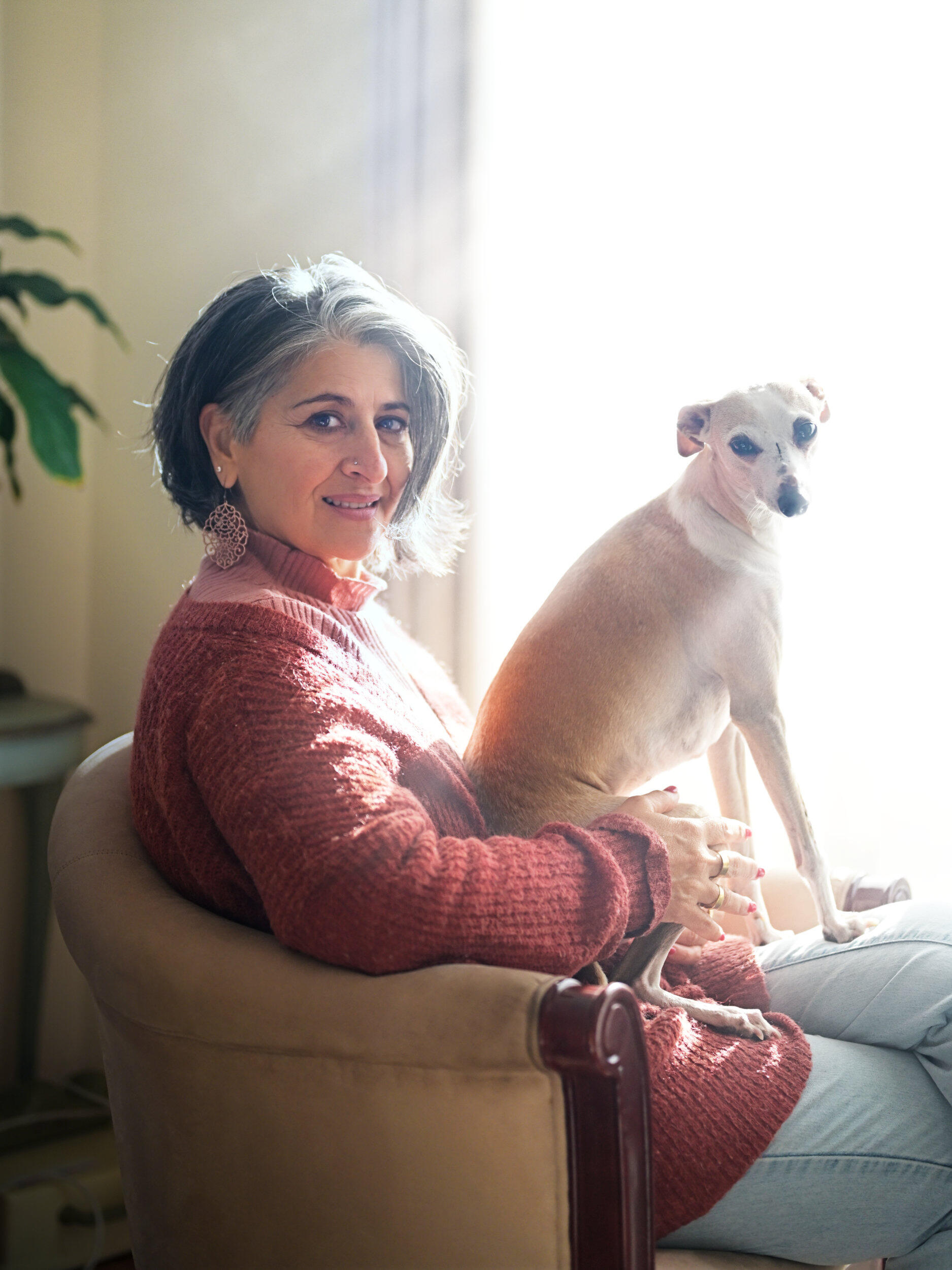 Woman and Dog A woman and her dog enjoying the filtered afternoon sun through the window on a Melbourne winters day.